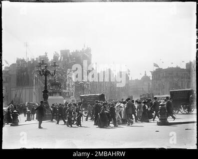 Charing Cross, City of Westminster, Greater London Authority, 1911. A busy street scene at Charing Cross, showing a policeman guiding pedestrians crossing the road to and from Trafalgar Square. The photograph is one of a batch taken by the photographer to show coronation decorations in London. Flags and bunting can be seen decorating the surrounding area for the coronation of King George V and Queen Mary on 22nd June 1911. Stock Photo