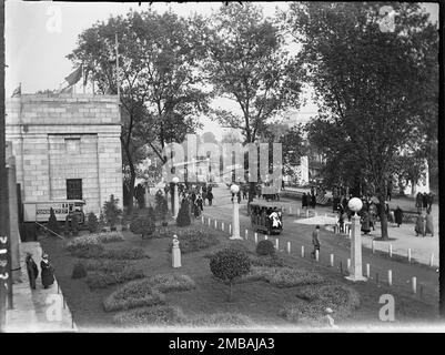 Wembley Park, Brent, Greater London Authority, 1924. Looking down from the tea balcony at the British Empire Exhibition in Wembley Park, showing people walking about the site and a 'Railodock' electric bus passing a garden in the foreground. The British Empire Exhibition opened on St George's Day 1924 with the aim of stimulating trade and strengthening bonds between the countries of the British Empire. The Railodock bus shown in the foreground was an electric bus used to transport people between the different exhibition buildings on the site. Stock Photo
