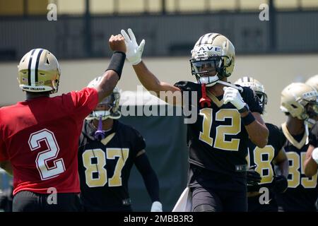 New Orleans Saints first round draft pick, wide receiver Chris Olave (12),  high fives quarterback Jameis Winston (2) during an NFL football practice  in Metairie, La., Thursday, June 2, 2022. (AP Photo/Gerald