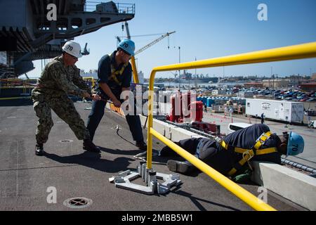 220614-N-TD381-1220 SAN DIEGO (June 14, 2022) Sailors assigned to Nimitz-class aircraft carrier USS Carl Vinson (CVN 70) lower an elevator safety net in preparation for attachment to the enlisted brow, June 14. Vinson is currently pierside in its homeport of San Diego. Stock Photo
