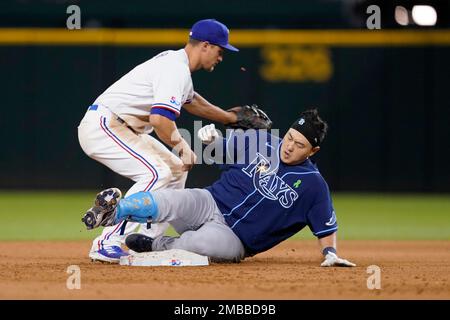 Texas Rangers' Corey Seager, left, greets Marcus Semien after his solo home  run off Cleveland Guardians starting pitcher Kirk McCarty during the third  inning of the second game of a baseball doubleheader