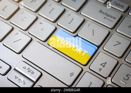 Support Ukraine, text and Ukrainian flag on silver keyboard enter key. I stand with Ukraine concept. Stock Photo