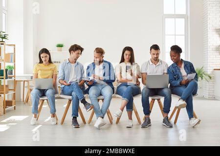 Group of students using modern digital devices at meeting Stock Photo