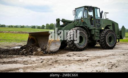 Spc. Kenneth Horey, a Fort Madison, Iowa, native and horizontal construction engineer assigned to the 831st Engineer Company, Iowa Army National Guard, moves dirt with a front end loader in the Camp Dodge training area in Johnston, Iowa, on June 14, 2022. The 831st EC was assigned to complete various projects around Camp Dodge during their annual training. Horey was helping to build the groundwork for new berms at the Infantry Squad Battle Course, which will allow for more realistic training in infantry tactics. Stock Photo