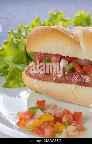 Detail of a choripan, typical argentine sandwich with chorizo and creole sauce. Stock Photo