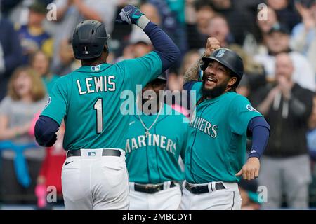 Seattle Mariners' Kyle Lewis (1) is greeted at the dugout by Taylor  Trammell, right, after Lewis hit a solo home run against the Houston Astros  during the second inning of a baseball