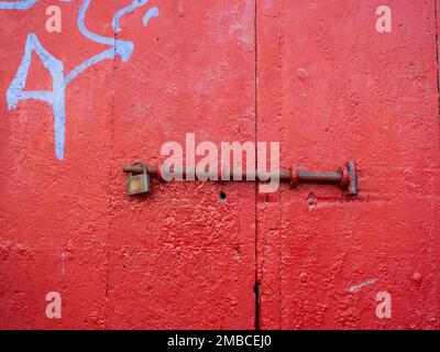 Red wooden door with security padlock Stock Photo