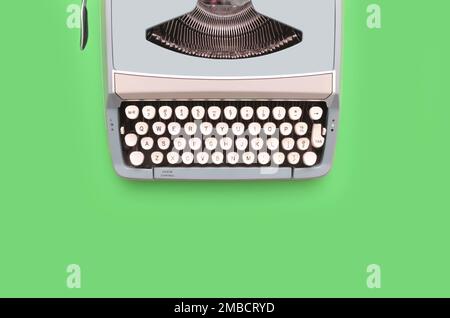Overhead top view of a vintage aqua blue typewriter against a green background Stock Photo