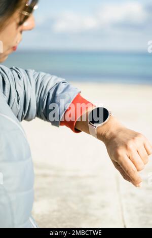 Smart watch. Smartwatch in the hand of a woman outdoors. Attractive young elegant woman with smartwatch. Latina woman wearing her wearable smartwatch Stock Photo