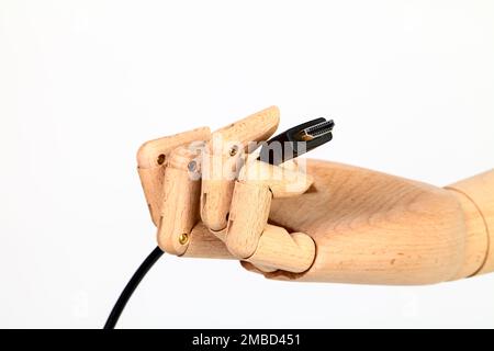 Wooden hand holding an HDMI cable isolated on a white background Stock Photo