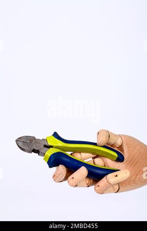 Wooden hand holding side cutters hand tool isolated on a white background Stock Photo