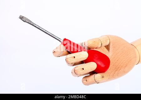 Wooden hand holding a slotted blade screwdriver isolated on a white background Stock Photo