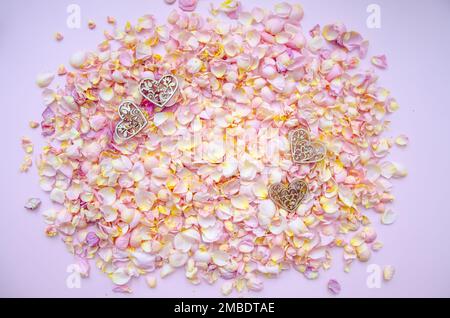Craft decorative wooden hearts, rose petals and buds on pink background.Valentines Day background and Copy space for your text. Card design. Love back Stock Photo