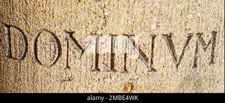 Dominum stands on a pillar in a church. This is Latin for the Lord. Seen in Rheine, Germany Stock Photo