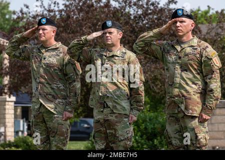 (Left to right) U.S. Army Lt. Col. Nicholas R. Talbot, the outgoing commander of the 1st Combined Arms Battalion, 63rd Armor Regiment, 2nd Armored Brigade Combat Team, 1st Infantry Division, U.S. Army Col. Brian Harris, the commander of the 2nd ABCT, 1st Inf. Div., and U.S. Army Lt. Col. Ryan R. Kroells, the incoming commander of the 1st Bn., 63rd Armor Regt., 2nd ABCT, 1st Inf. Div., render salute to the American flag during the playing of the National Anthem at the battalion’s change of command ceremony on the Fort Riley, Kansas, Cavalry Parade Field, June 15, 2022. Talbot, Harris and Kroell Stock Photo