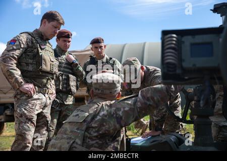 Staff Sgt. Dennis Yi, a U.S. Army Soldier assigned to Alpha Battery, 2nd Battalion, 146th Field Artillery Regiment, Washington Army National Guard, conducts a howitzer familiarization class for British and Romanian soldiers at Bemowo Piskie Training Area, Bemowo Piske, Poland, June 15, 2022. Stock Photo