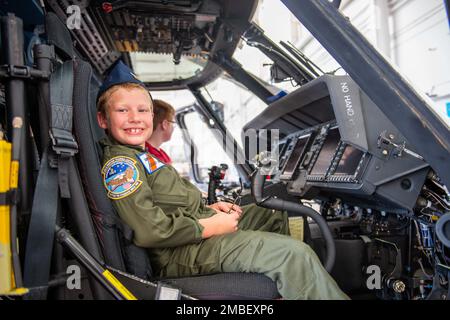 Ethan Thomas, an honorary aviator, sits behind the controls of an MH-60 Jayhawk helicopter at Coast Guard Aviation Training Center in Mobile, Alabama, June 15, 2022. Ethan was chosen to be part of ATC Mobile's Pilot-for-a-day program, which allows selected persons to visit the unit and have an in-depth tour of the aircraft and facilities. Stock Photo