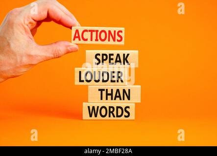 Actions speak louder words symbol. Concept words Actions speak louder than words on wooden blocks. Beautiful orange table orange background. Business Stock Photo