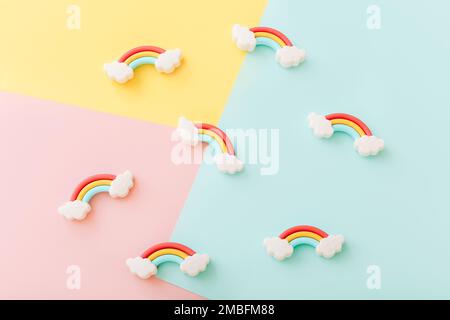 Rainbow erasers with smiling clouds on color background, top view Stock Photo