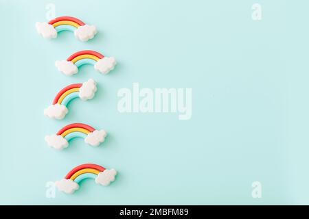 Rainbow erasers with smiling clouds on color background, top view Stock Photo