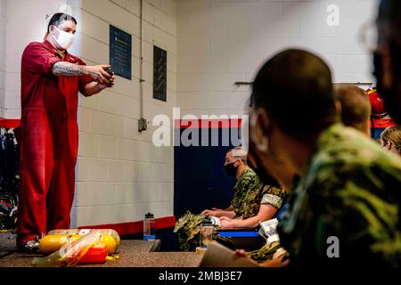 220616-N-PW480-0145 GREAT LAKES, Ill. (June 16, 2022) – Damage Controlman 1st Class Manuel Jimenez, a firefighting and damage control instructor at Recruit Training Command (RTC), leads Naval Reserve Officer Training Corps (NROTC) New Student Indoctrination (NSI) midshipman candidates in a self-contained breathing apparatus (SCBA) training, June 16. Upon completion of NSI, the candidates will start their freshman year of the NROTC program at colleges and universities nationwide this fall. NSI is an indoctrination program hosted at RTC, and provides midshipmen with a common military training or Stock Photo