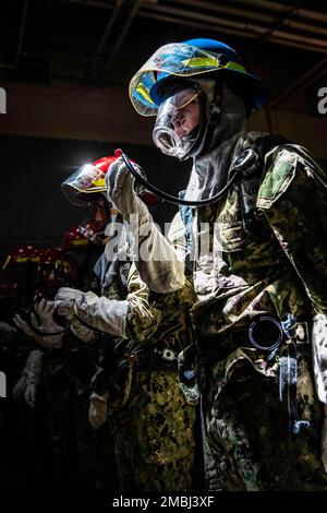 220616-N-PW480-0288 GREAT LAKES, Ill. (June 16, 2022) – Naval Reserve Officers Training Corps (NROTC) New Student Indoctrination (NSI) midshipman candidates don firefighting equipment during a firefighting and damage control training exercise inside the USS Chief Fire Fighter Trainer at Recruit Training Command (RTC), June 16. Upon completion of NSI, the candidates will start their freshman year of the NROTC program at colleges and universities nationwide this fall. NSI is an indoctrination program hosted at RTC, and provides midshipmen with a common military training orientation. NSI provides Stock Photo