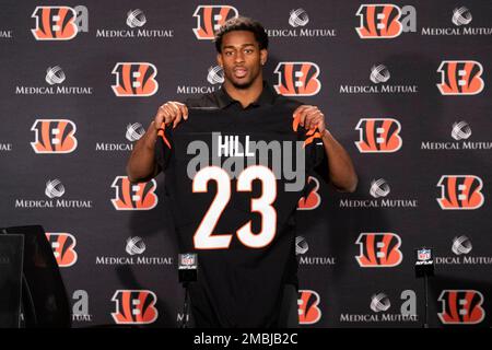 Cincinnati Bengal Daxton Hill holds up a team jersey for a photo after  being introducing as