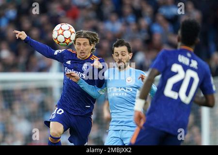 Real Madrid's Luka Modric, right, heads the ball past Manchester