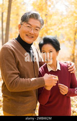 The elderly couple walking in the ginkgo forest Stock Photo