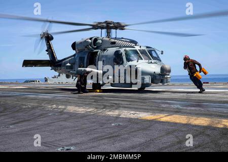 220617-N-OL632-1046 ATLANTIC OCEAN (June 17, 2022) Sailors prepare an MH-60R Sea Hawk helicopter assigned to Helicopter Maritime Strike Squadron (HSM) 46 for take off aboard the Nimitz-class aircraft carrier USS George H.W. Bush (CVN 77), June 17, 2022. The George H.W. Bush Carrier Strike Group (CSG) is underway completing a certification exercise to increase U.S. and allied interoperability and warfighting capability before a future deployment. The George H.W. Bush CSG is an integrated combat weapons system that delivers superior combat capability to deter, and if necessary, defeat America's Stock Photo
