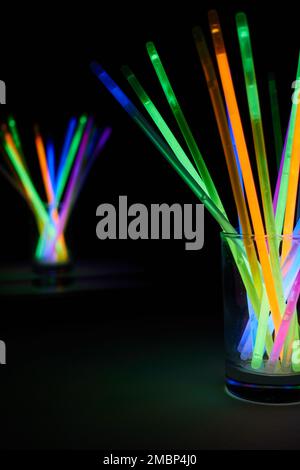 arrangement of multi-colored glow sticks against a black background  Stock Photo