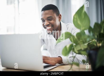 Hard work never ends, even if it is at home. a handsome young businessman sitting alone and using his laptop to work from home. Stock Photo