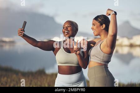 We in on the bestie fitness challenge. two women taking a selfie while out for a run.together. Stock Photo