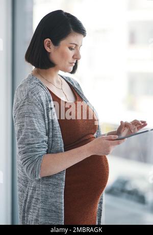 What are my rights as a pregnant worker. a pregnant young businesswoman using a digital tablet in a modern office. Stock Photo