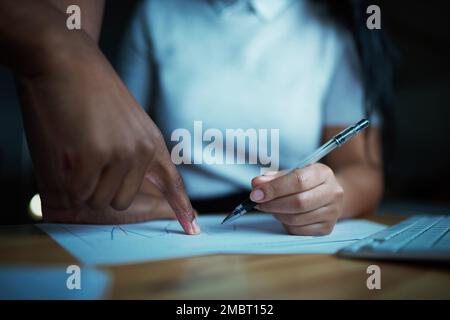 Numbers dont work unless we do. unrecognisable businesspeople analysing financial reports during a late night at work. Stock Photo