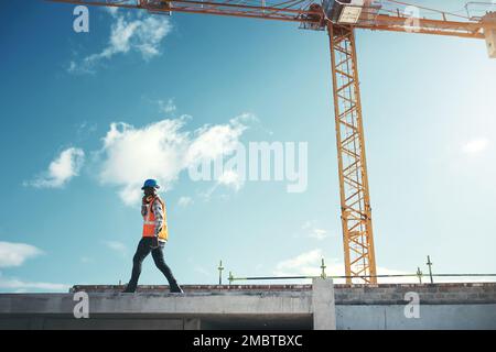 Next level quality construction. a young man using a smartphone while working at a construction site. Stock Photo