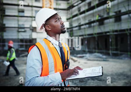 See beyond the brick. a young man going over building plans at a construction site. Stock Photo