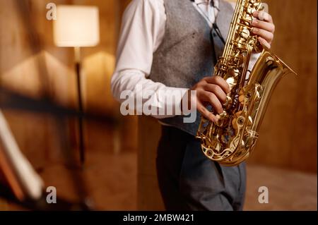 Cropped shot of young musician standing and playing saxophone Stock Photo