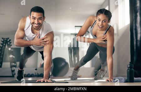 Partner up and make working out fun. two young athletes working out together at the gym. Stock Photo