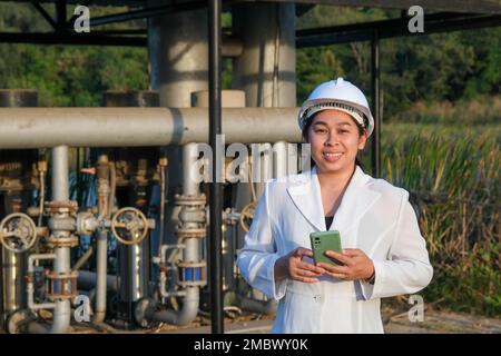 Environmental engineer in white helmet working at wastewater treatment plant. Water supply engineering working at Water recycling plant for reuse. Wat Stock Photo