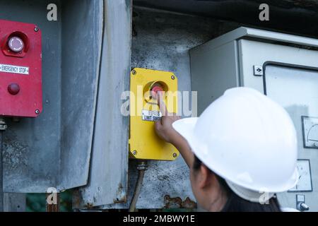 Portrait of professional Asian electrical engineer turning on the switches. Stock Photo