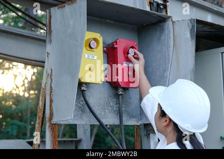 Portrait of professional Asian electrical engineer turning on the switches. Stock Photo