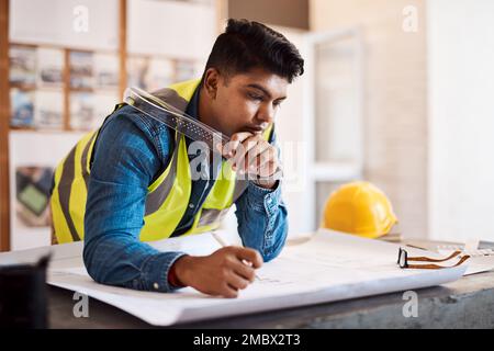 Theres no room for error when it comes to blueprints. a young architect drawing up a building plan in his office. Stock Photo