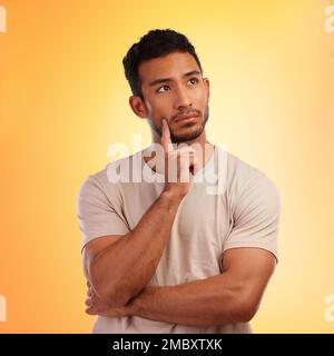 Thinking, wondering and thoughtful Asian man with a choice isolated on a yellow background in a studio. Curious, think and Japanese person with a Stock Photo
