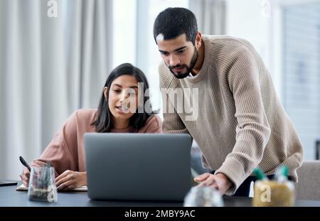 Marriage is the greatest project youll work on. a young man and woman using a laptop while working from home. Stock Photo