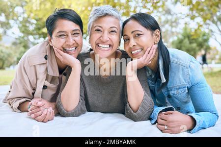 Portrait, senior women and friends at park on picnic blanket, bonding and enjoying quality time together outdoors. Peace, retirement and happy group Stock Photo