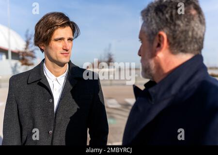 Pensive businessmen in smart clothes looking at each other while having conversation about work on sunny day Stock Photo