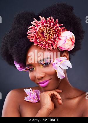 Flowers is the best accessory. Studio shot of a beautiful young woman posing with flowers in her hair. Stock Photo