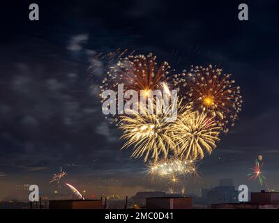 Bright fireworks and sparks in the night sky. City celebrating traditional holiday with colorful fireworks explosions. Long exposure shot. Night scene Stock Photo