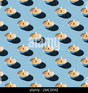 Seamless pattern of burning tea light candles. Lit candle casts shadow on a blue pastel surface repeating pattern. Background for aromatherapy and spa Stock Photo